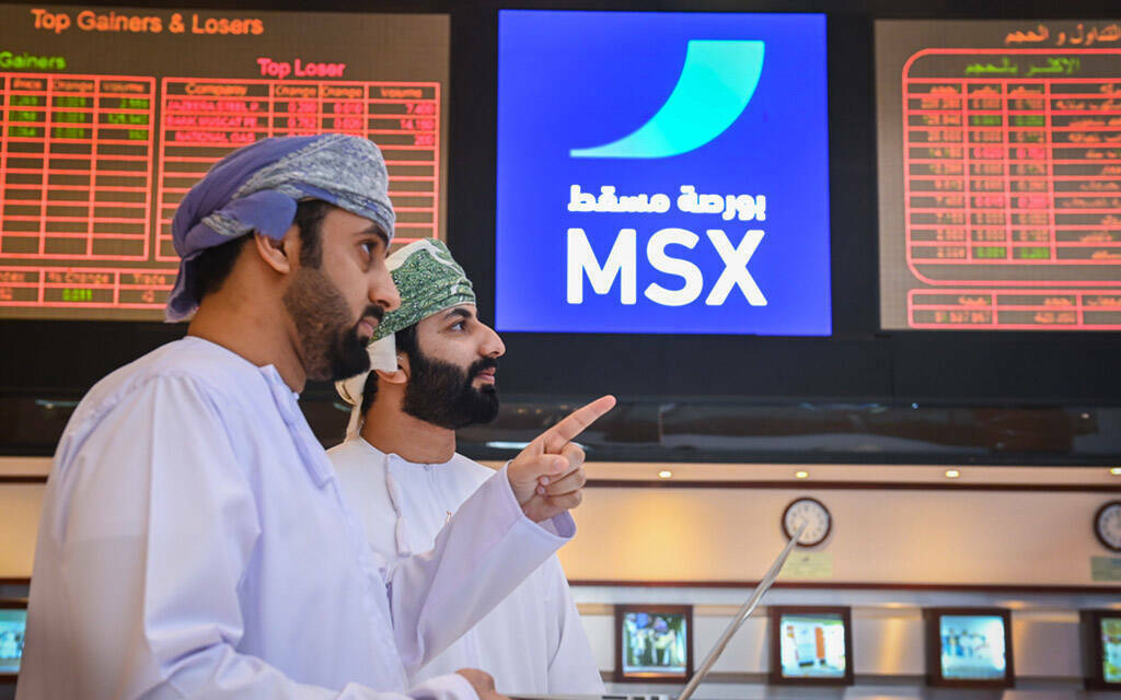 مستثمرون يتابعون أسعار الأسهم بسوق مسقط