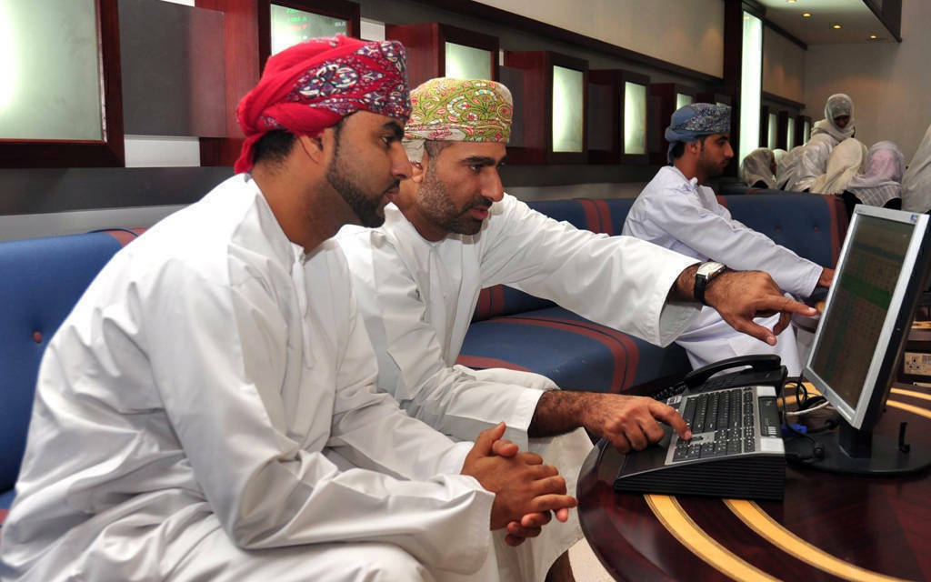 مستثمرون يتابعون أسعار الأسهم بقاعة التداولات